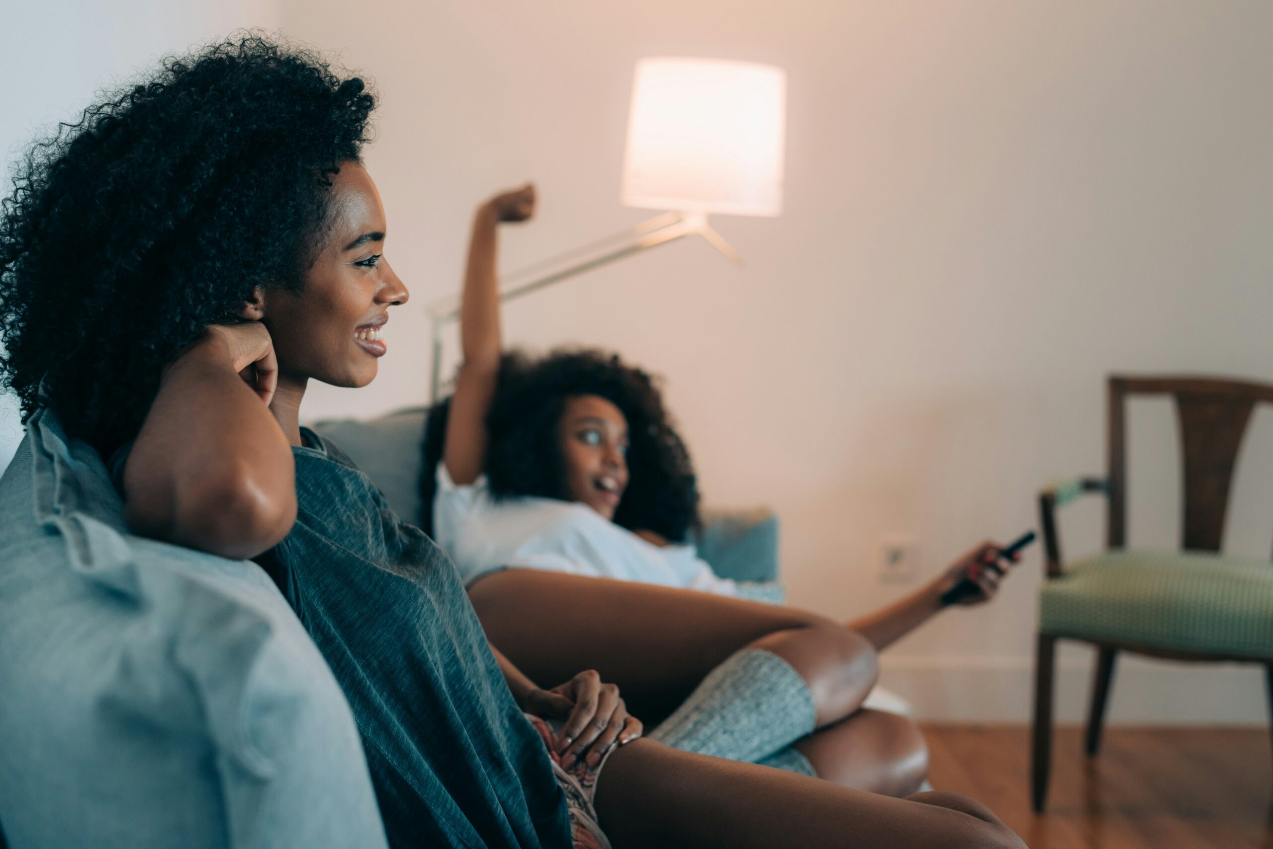 Two women watch TV on the couch