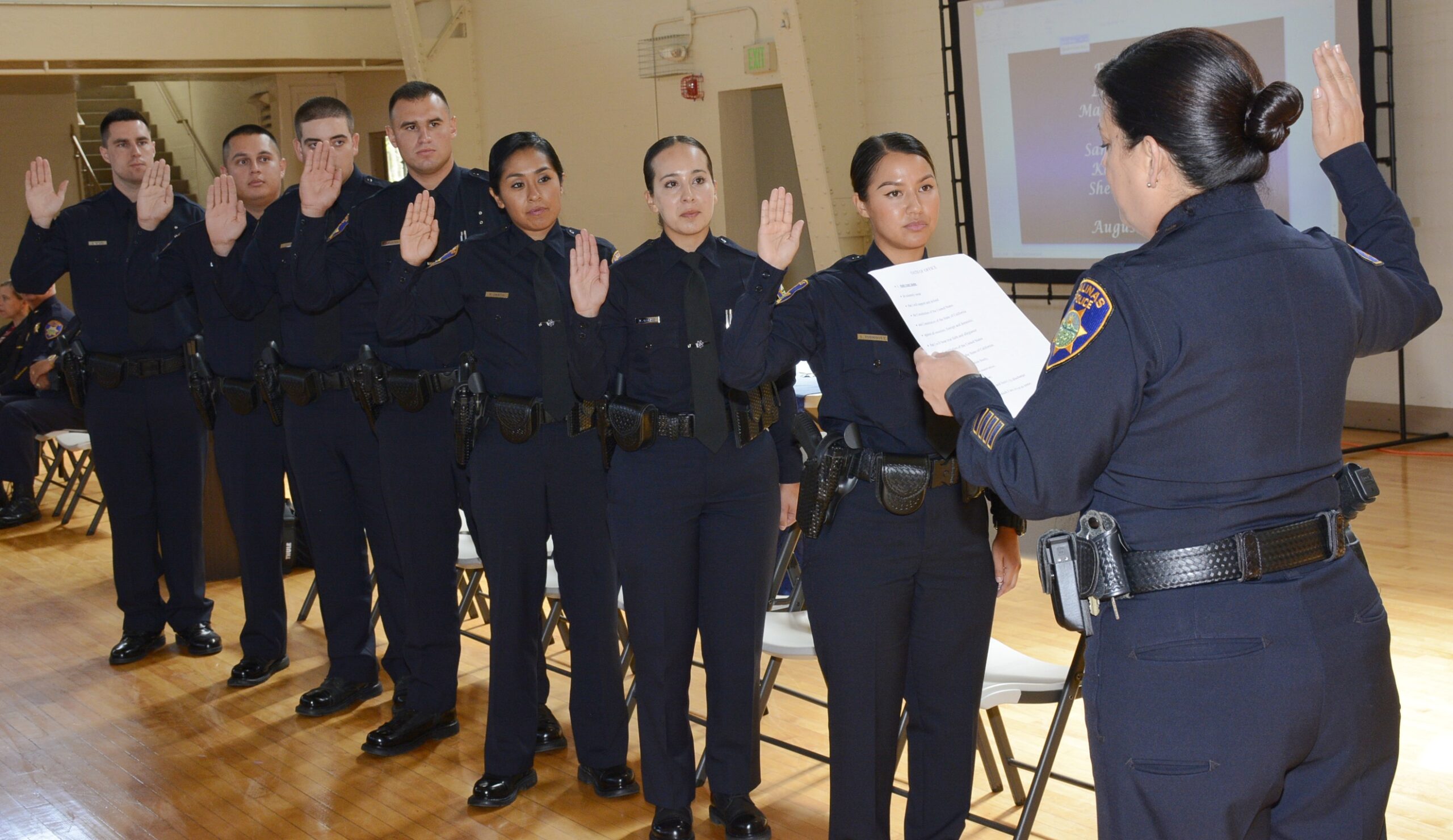 An officer swears in eight cadets of the Salinas Police Department