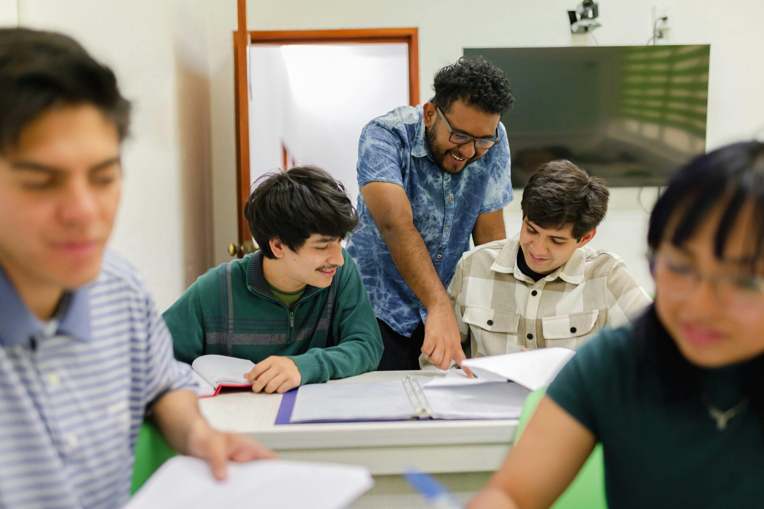 jordan-gonzalez-lsyl3kpQgIU-unsplash An instructor points out examples to a diverse group of students in an intimate classroom setting.